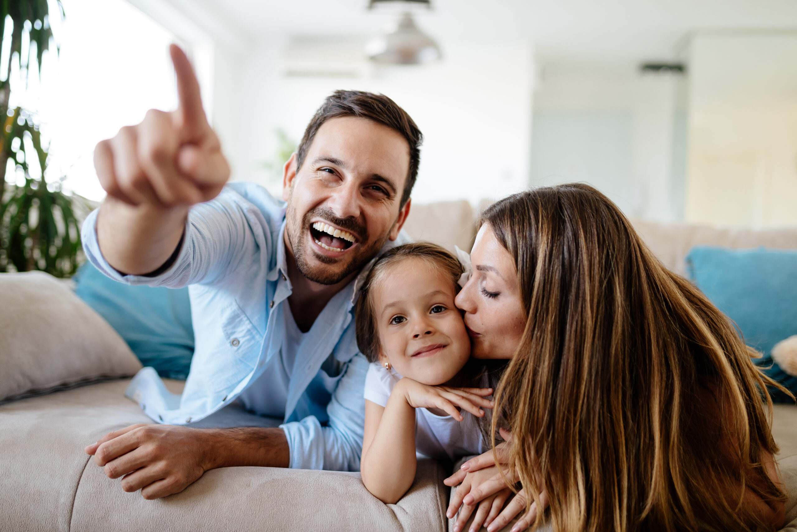 Happy family watching television at their home Glückliche Familie schaut gemeinsam zu Hause fern