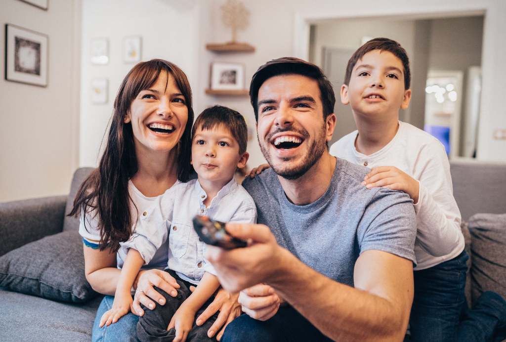IPTV Familie vor dem Fernseher mit Fernbedienung in der Hand